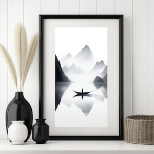 Op de afbeelding: Zwart-wit minimalistische kunstprint van een enkele boot op een meer met bergen op de achtergrond. De bergen worden weerspiegeld in het water.