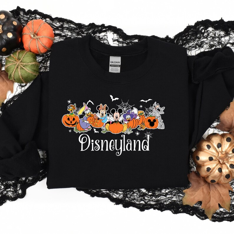 May include: Black sweatshirt with a Halloween-themed design featuring Mickey Mouse and other Disney characters dressed in costumes. The characters are holding pumpkins and the text "Disneyland" is printed below them.