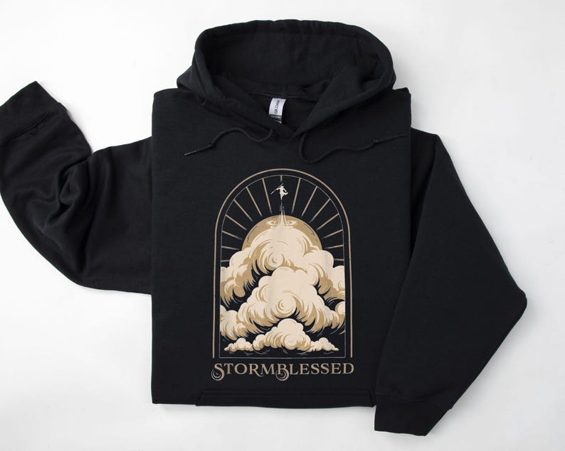 May include: Black hooded sweatshirt with a graphic of a person standing on a cloud with the text "STORMBLESSED" below.