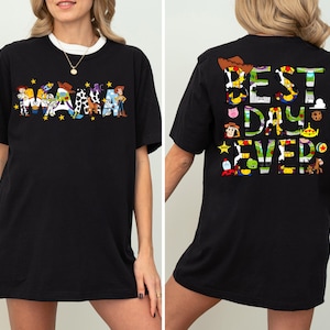 Puede incluir: Camiseta negra con un gr&aacute;fico de personajes de Toy Story que deletrean "MAMA" en la parte delantera y "BEST DAY EVER" en la parte trasera.