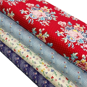 May include: A stack of fabric rolls in various floral and geometric patterns. The top roll is red with white polka dots and large floral bouquets. Other rolls include light blue, cream, and navy fabrics with smaller floral and grid designs.