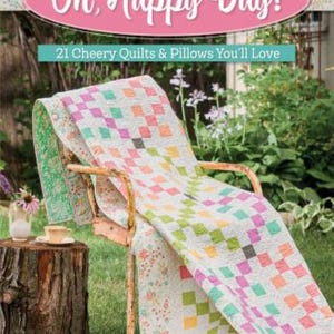 May include: A colorful quilt with a diamond pattern draped over a vintage chair. The quilt features squares of pink, green, orange, and yellow. The image includes a book cover that reads "Oh, Happy Day!" and "21 Cheery Quilts & Pillows You'll Love."
