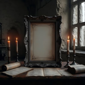 Puede incluir: Un marco vintage, adornado, pintado en plata con un interior blanco en blanco, rodeado de tres velas encendidas en candelabros antiguos, y papel pergamino viejo enrollado y libros abiertos sobre una mesa de madera.