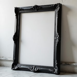 May include: A large, black, ornate picture frame with a white background. The frame has a decorative, carved design.
