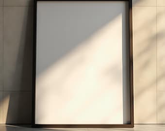 May include: A black framed poster mockup with a white background. The poster is leaning against a light beige tiled wall.