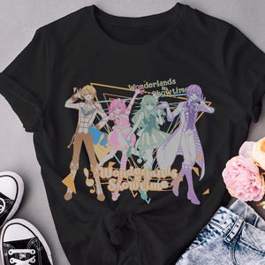 May include: Black t-shirt featuring a colorful illustration of four anime-style characters in dynamic poses. The text "Wonderlands x Showtime" is displayed in a stylized font. A pair of black canvas sneakers are visible in the lower left corner.