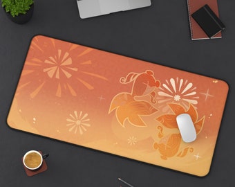 May include: An orange and yellow desk mat with a decorative floral design and a black border. A white computer mouse rests on the mat. The mat is surrounded by a laptop, pencils, a notebook, and a cup of coffee.