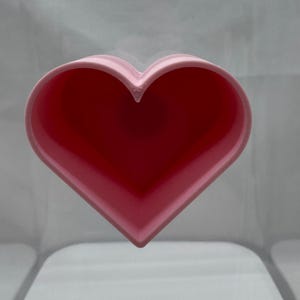 May include: A pink heart-shaped silicone mold for baking or crafting.