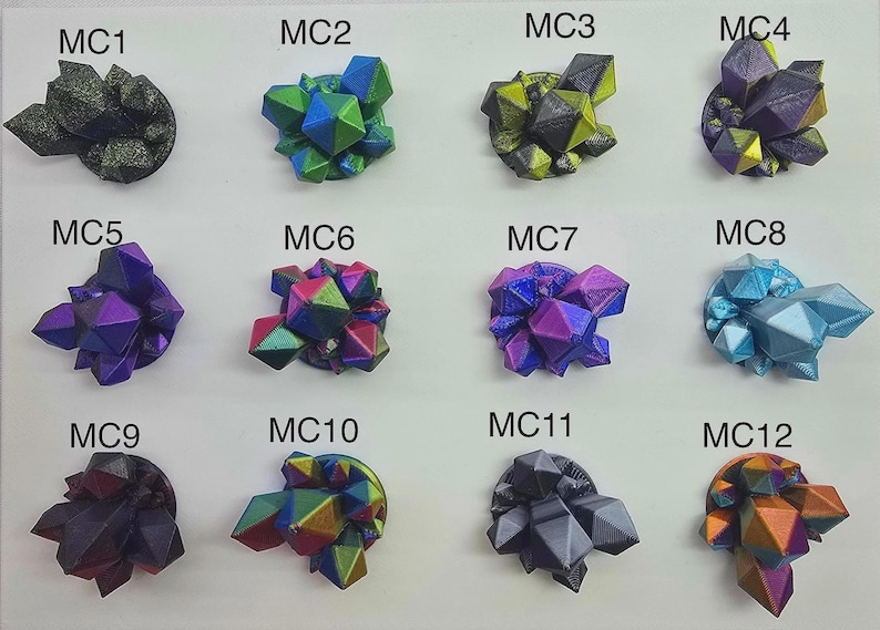 May include: A collection of twelve colorful, geometric crystal formations. Each cluster features a unique blend of colors, including blues, greens, purples, and golds. The crystals are arranged on a white surface, labeled MC1 through MC12.