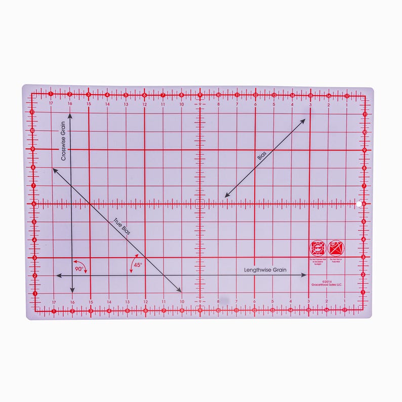 Pode incluir: R&eacute;gua de quilting retangular transparente com linhas e marca&ccedil;&otilde;es vermelhas. A r&eacute;gua apresenta medidas, &acirc;ngulos e etiquetas direcionais como "Crosswise Grain" e "True Bias". &Eacute; projetada para corte de tecido.