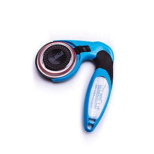Puede incluir: Un cortador rotatorio azul y negro con un mango de pl&aacute;stico transparente. El mango tiene el texto "TrueCut Easy Safe Accurate" impreso en &eacute;l. El cortador est&aacute; dise&ntilde;ado para cortar tela.