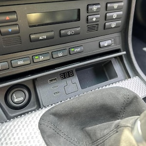 May include: Close-up of a car's dashboard with a digital display showing "8.8.8" and various buttons, including "AUTO", "SPORT", and "DSC".