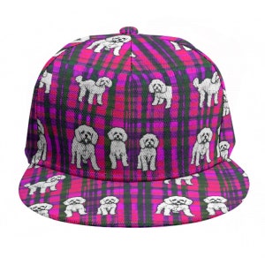 Puede incluir: Una gorra de béisbol de cuadros rosa y negro con un patrón de caniche blanco.
