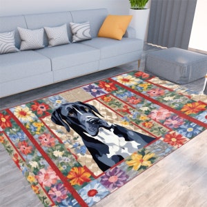 May include: A rectangular area rug featuring a Great Dane dog portrait surrounded by a floral border. The rug has a beige background with a diamond pattern, and the border is red with colorful flowers.