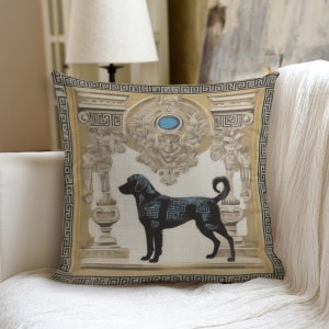 Puede incluir: Una almohada decorativa con una silueta negra de un perro de pie frente a un diseño ornamentado dorado y blanco. La almohada tiene un borde de llave griega.