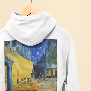 Puede incluir: Sudadera blanca con una impresión de la pintura de Vincent van Gogh "La terraza de un café por la noche". La pintura representa una terraza de café por la noche con un cielo estrellado y personas sentadas en mesas.