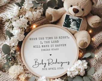 Può includere: Un cartello rotondo in legno bianco con il testo "WHEN THE TIME IS RIGHT, I, THE LORD WILL MAKE IT HAPPEN ISAIAH 60:22 Baby Rodriguez DUE APRIL 2025". Il cartello è circondato da fiori bianchi e un orsacchiotto di peluche marrone che tiene un'immagine di ecografia.