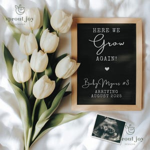 May include: A chalkboard sign with the text "Here We Grow Again!" and "Baby Myers #3 Arriving August 2025". White tulips and an ultrasound image are in the background.