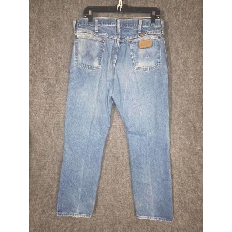 Calça jeans masculina Wrangler Cowboy Cut de perna reta, lavagem clara, azul, tamanho 36x32, com detalhes desgastados. imagem 2