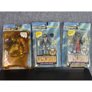 May include: Three action figures in their original packaging. The figures are labeled Cy-Gor, Grail, and Vampire. The packaging features the Wetworks Ultra-Action Figures logo and lightning bolt graphics.