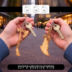 Op de afbeelding: Twee houten sleutelhangers, een in de vorm van een bijl en de andere in de vorm van een gebogen mes, worden getoond. Elke sleutelhanger is bevestigd aan een sleutel. De tekst "Kratos Blades Keychain Design Cut & Burning File" staat onderaan.
