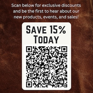 May include: A white rectangle with the text "SAVE 15% TODAY" and a QR code is displayed against a brown leather background. The text "Scan below for exclusive discounts and be the first to hear about our new products, events, and sales!" is above the rectangle.