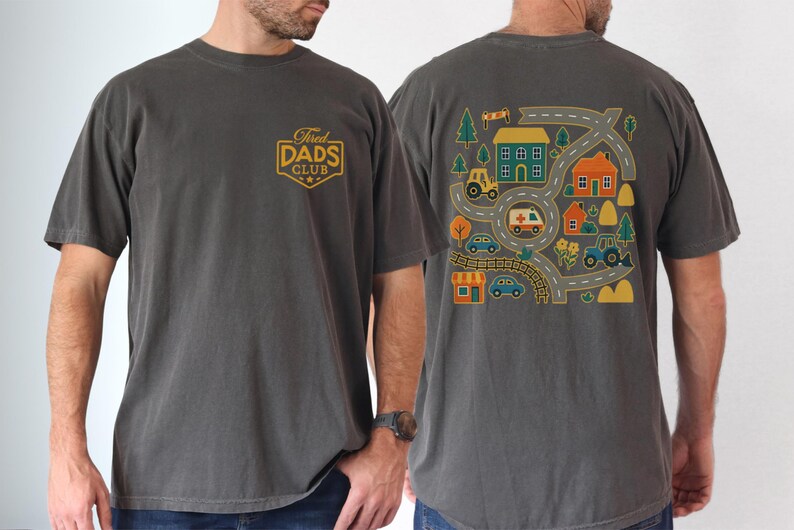 May include: Dark gray t-shirt with the text "Tired Dads Club" on the front and a colorful road map design on the back. The back design includes houses, cars, and a tractor.