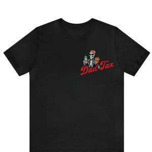 May include: Black t-shirt with a skeleton graphic on the left chest. The skeleton wears a cap and holds a drink and fries. Red script text reads "Dad Tax".