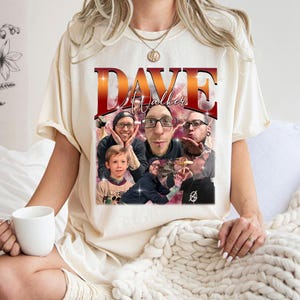 May include: A white t-shirt with a graphic print of a collage of photos. The text "DAVE Walker" is printed in red and white letters on the shirt.