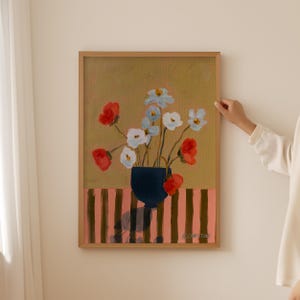 Può includere: Un dipinto di un mazzo di fiori rossi, bianchi e blu in un vaso blu scuro. I fiori sono su uno sfondo a strisce con strisce rosa e marroni. Il dipinto è firmato "S. Christine".