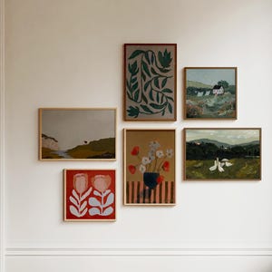May include: A gallery wall with six framed paintings. The paintings feature a variety of subjects, including flowers, landscapes, and abstract designs. The paintings are arranged in a symmetrical pattern on a white wall.