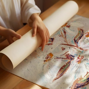 May include: A person is rolling up a white canvas painting with abstract floral designs in shades of pink, blue, yellow, and green.