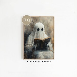 May include: A white ghost with two black eyes is sitting and reading a large, old, brown book. The ghost is wearing a white sheet and is sitting in a chair. The background is a light brown colour. The image is titled "Riverdale Prints".