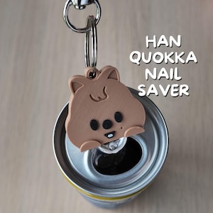 May include: A white ceramic mug with a black handle and the text "But First, Coffee" in a black, handwritten-style font. The mug is on a white surface.