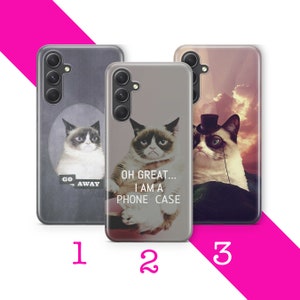 Può includere: Tre diverse custodie per telefono con un gatto scontroso con diversi detti. La prima custodia ha uno sfondo grigio con il testo "Go Away". La seconda custodia ha uno sfondo bianco con il testo "Oh Great... I am a Phone Case". La terza custodia ha uno sfondo di tramonto con il gatto che indossa un cappello a cilindro e un monoccolo.