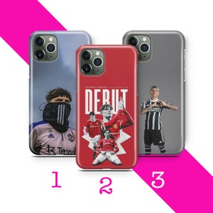 Könnte beinhalten: Drei verschiedene Handyhüllen mit Bildern von Fußballspielern. Die erste Hülle hat einen blauen Himmel als Hintergrund mit einem Fußballspieler, der ein weißes und rosafarbenes Trikot trägt. Die zweite Hülle hat einen roten Hintergrund mit einem Fußballspieler in einem roten Trikot. Die dritte Hülle hat einen grauen Hintergrund mit einem Fußballspieler in einem schwarz-weißen Trikot.