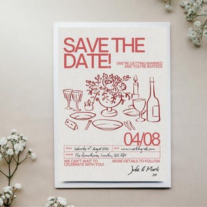 Puede incluir: Una invitación de boda con una ilustración roja sobre fondo crema. El texto "SAVE THE DATE!" está en la parte superior, con detalles como la fecha, el lugar y la información RSVP. La ilustración representa una mesa con arreglos florales.