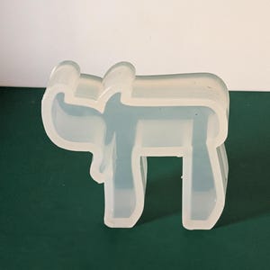 May include: A clear silicone mold shaped like a moose. The mold is designed for making resin crafts.