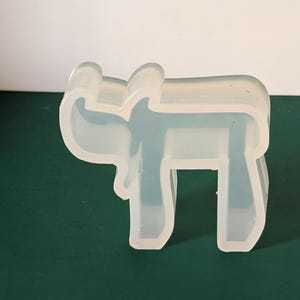 May include: A clear silicone mold shaped like the Hebrew letter 'Chai'.