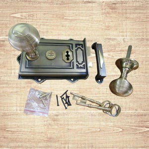 Könnte beinhalten: Antikes Türschloss-Set aus Bronze mit rundem Türknauf, rechteckigem Schloss, Riegel und zweitem Türknauf. Inklusive Schlüssel und Schrauben. Die Hardware hat eine Vintage-Ästhetik.