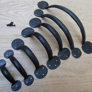 以下が含まれることがあります： さまざまなサイズの黒い鍛造鉄製ハンドル7個セット。それぞれが湾曲したグリップと丸い取り付けプレートを備えています。ネジの小さな山が含まれています。 キャビネットや引き出しに最適です。