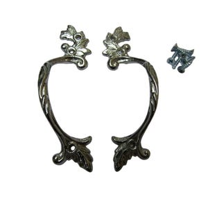 May include: Two silver-toned cabinet handles with a floral design. Each handle has a curved shape with decorative leaf accents at the ends and top. A small pile of screws is included, suggesting easy installation for furniture or cabinetry.