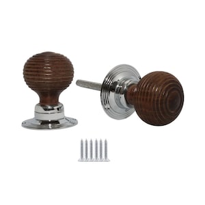 May include: Two wooden door knobs with a ribbed design and a polished chrome base. The knobs are a dark brown colour and are accompanied by a set of silver screws. The door knobs are designed for interior doors.