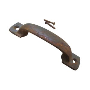 Puede incluir: Un tirador de metal oxidado y curvado con dos tornillos. El tirador tiene una base rectangular con un agujero para el montaje y un agarre curvado. El metal tiene un aspecto envejecido, lo que sugiere que es un artículo antiguo o vintage.