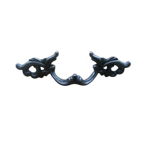 Może przedstawiać: Ciemnoszary, ozdobny uchwyt do szuflady z zakrzywionym uchwytem i dekoracyjnymi akcentami kwiatowymi. Okucia są wykonane z metalu i mają styl vintage lub antyczny, idealny do renowacji mebli lub projektów DIY.