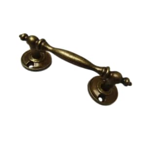 May include: Antique brass drawer pull with a curved handle and decorative circular backplates. The hardware has a vintage aesthetic, suitable for cabinets or furniture. The pull measures approximately 13 cm in length.