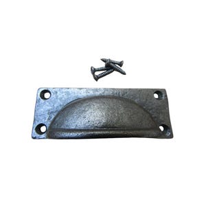 May include: A cast iron drawer pull with a semi-circular handle and four screw holes. The hardware is a dark gray color and includes three screws. This rustic style pull is suitable for cabinets and drawers.