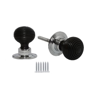 May include: Two black door knobs with a ribbed design and chrome bases. The knobs are round and have a classic, vintage style. Several silver screws are included. Ideal for adding a touch of elegance to any door.