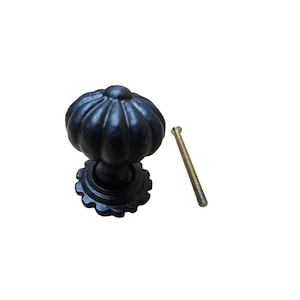 Könnte beinhalten: Schwarzer Schrankknauf mit einem kürbisförmigen Design und einem dekorativen Sockel. Eine goldfarbene Schraube ist im Lieferumfang enthalten. Der Knauf ist wahrscheinlich aus Metall und eignet sich für Möbel oder Schränke.