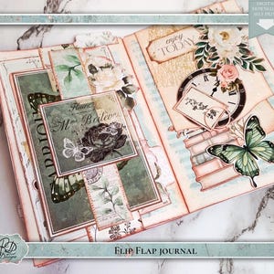 Könnte beinhalten: Offenes Flip-Flap-Journal mit Vintage-Ästhetik. Das Journal enthält dekorative Elemente wie Schmetterlinge, Blumen und eine Uhr. Der Text "ADD IO" und "Mme Boileve" sind sichtbar. Das Journal ist mit "FLIP FLAP JOURNAL" beschriftet.
